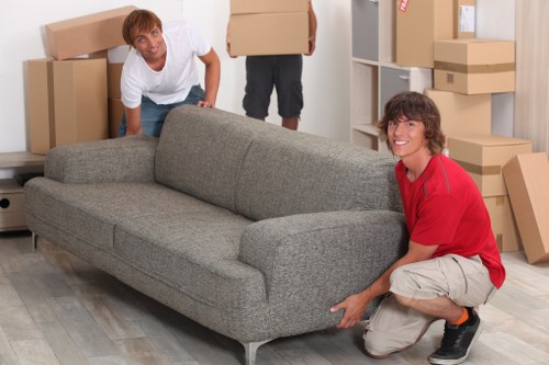 Furniture collection team handling bulky items in Swiss Cottage apartment building